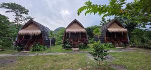a group of three huts with grass roofs at Bilva Garden Penida in Polilit