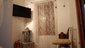 a room with a window with a television on a wall at George's house samos in Pagóndas