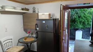 a black refrigerator in a kitchen with a table at George's house samos in Pagóndas