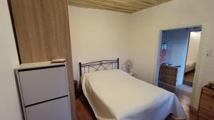 a bedroom with a white bed and a dresser and a door at George's house samos in Pagóndas +35 photos
