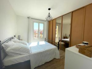 a bedroom with a white bed and a mirror at VERLAINE House in Menton