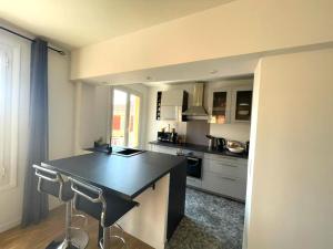 a kitchen with a black counter top in a room at VERLAINE House in Menton