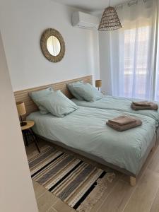 a bedroom with a large bed with towels on it at Les palmiers Maxime in Sainte-Maxime