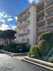 a tall apartment building with bushes in front of it at Les palmiers Maxime in Sainte-Maxime
