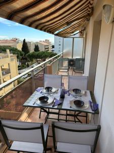 a table and chairs on a balcony with a view at Les palmiers Maxime in Sainte-Maxime