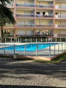 a swimming pool in front of a building at Les palmiers Maxime in Sainte-Maxime