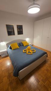 a large bed with a yellow ribbon on it at La Casa di Draf Appartamento Humanitas IEO Forum in Rozzano