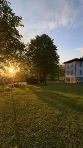 a field of grass with a building and a tree at Albergo Santa Maria in Esino Lario