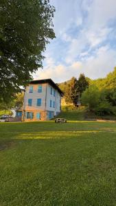 a building in a field with a bench in front of it at Albergo Santa Maria in Esino Lario +16 photos