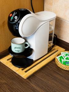 a coffee maker and a cup on a wooden tray at Belle vue des Alpes in Blavy