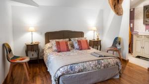 a bedroom with a large bed and two chairs at L'OUSTAL D'ADELE proche Canal du Midi et Moissac in Saint-Nicolas-de-la-Grave