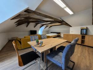 a living room with a wooden table and chairs at Zelena Ratolest in České Budějovice