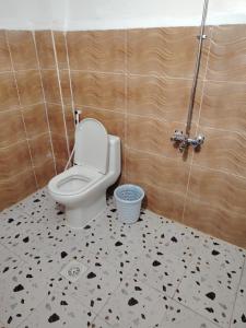 a bathroom with a white toilet and a black and white floor at Nour Taba Apartments in Medina +18 photos