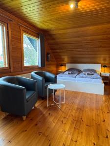 a bedroom with two beds and two chairs at Finnische Blockhäuser in Gartow