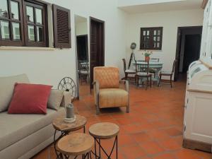 a living room with a couch and chairs and a table at Paraíso das Flores in Pataias
