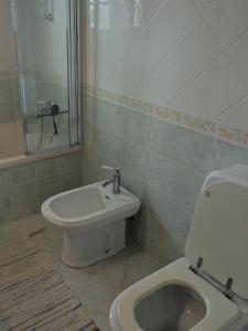 a bathroom with a toilet and a sink at Paraíso das Flores in Pataias
