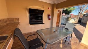 a table and chairs in a kitchen with a fireplace at Guesthouse 116 on McLean in Welkom