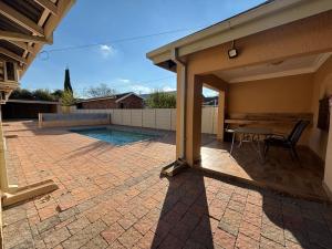 a patio with a table and a pool at Guesthouse 116 on McLean in Welkom