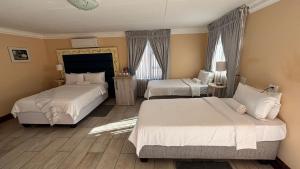 a hotel room with two beds and two windows at Guesthouse 116 on McLean in Welkom +28 photos