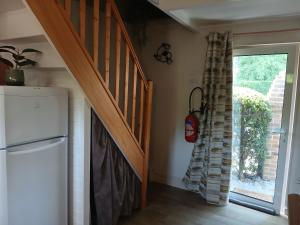 a kitchen with a staircase and a refrigerator and a door at Le Chalet de Gonnehem in Gonnehem +3 photos
