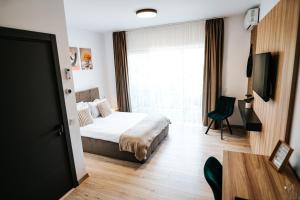 a bedroom with a bed and a table and a window at Riverside ApartHotel by InnTime in Cluj-Napoca