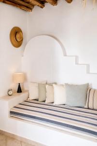 a white room with a bench with pillows at Lemonia House in Vívlos +15 photos