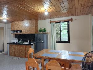 a kitchen with a wooden table and a wooden ceiling at Gia's Baguio Transient House in Baguio