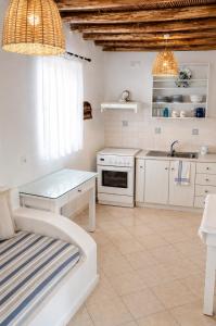 a kitchen with white cabinets and a table and a sink at Lemonia House in Vívlos