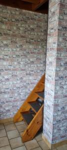 a wooden staircase in a brick wall at Duplex le Randonneur - Les Apparts du Sancy in Chastreix