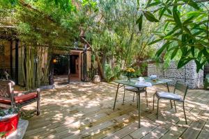 a patio with a table and chairs and trees at les Aromatiques - terrasse & parking privé à VILLENEUVE LES AVIGNON - proche Golf Academy in Villeneuve-lès-Avignon +9 photos