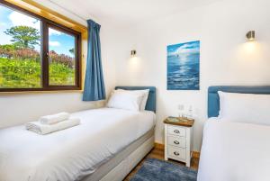 two beds in a room with a window at L54 - Sunny Corner in Truro