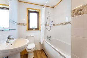 a bathroom with a sink and a toilet and a bath tub at L54 - Sunny Corner in Truro