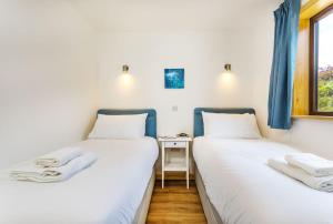 two twin beds in a room with a window at L54 - Sunny Corner in Truro +6 photos