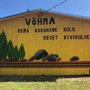 a yellow building with a sign on the side of it at Võhma Külamaja, room nr 8 in Võhma