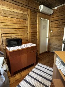 a room with a wooden wall with a stove at Võhma Külamaja, room nr 8 in Võhma