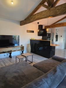 a living room with a couch and a piano at Gîte de la Daudière La Grange in Le Boupère