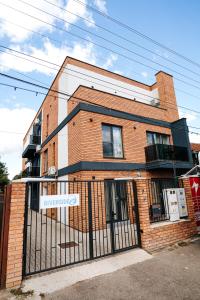 a brick building with a gate in front of it at Riverside ApartHotel by InnTime in Cluj-Napoca