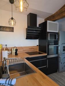 a kitchen with a sink and a microwave at Gîte de la Daudière La Grange in Le Boupère +7 photos