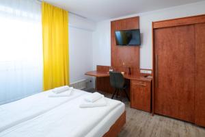 a room with two beds and a desk with a computer at Hotel zur Post in Herne