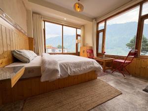 a bedroom with a bed and a large window at Jamming Tree in Manāli