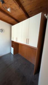 an empty room with white cabinets and a wooden ceiling at Casa Mango in Stresa