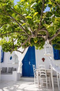 a table and chairs under a tree in front of a blue door at Lemonia House in Vívlos