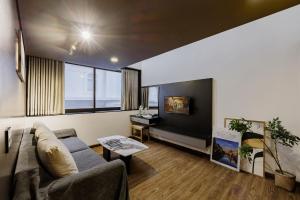 a living room with a couch and a tv at TTR Rin Villa & Hotel in Da Lat