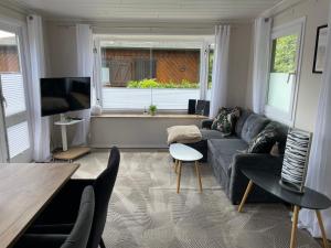 a living room with a couch and a tv at Marla zum Strand in Garrel