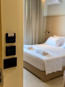 a hotel room with a bed and a picture of a bedroom at RAI Rooms Saranda in Sarandë