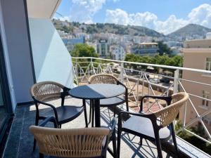 a balcony with tables and chairs and a view of a city at RAI Rooms Saranda in Sarandë