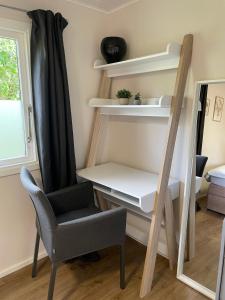 a room with a chair and a desk and a mirror at Marla zum Strand in Garrel