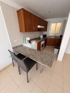 a kitchen with a counter and a table and chairs at relax by the sea in Puerto de Santiago
