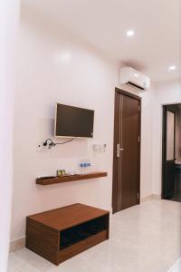 a living room with a tv on the wall at R Hotell in Sầm Sơn