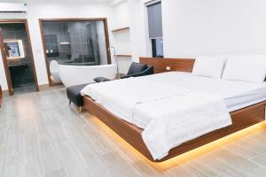 a bedroom with a large bed and a chair at R Hotell in Sầm Sơn